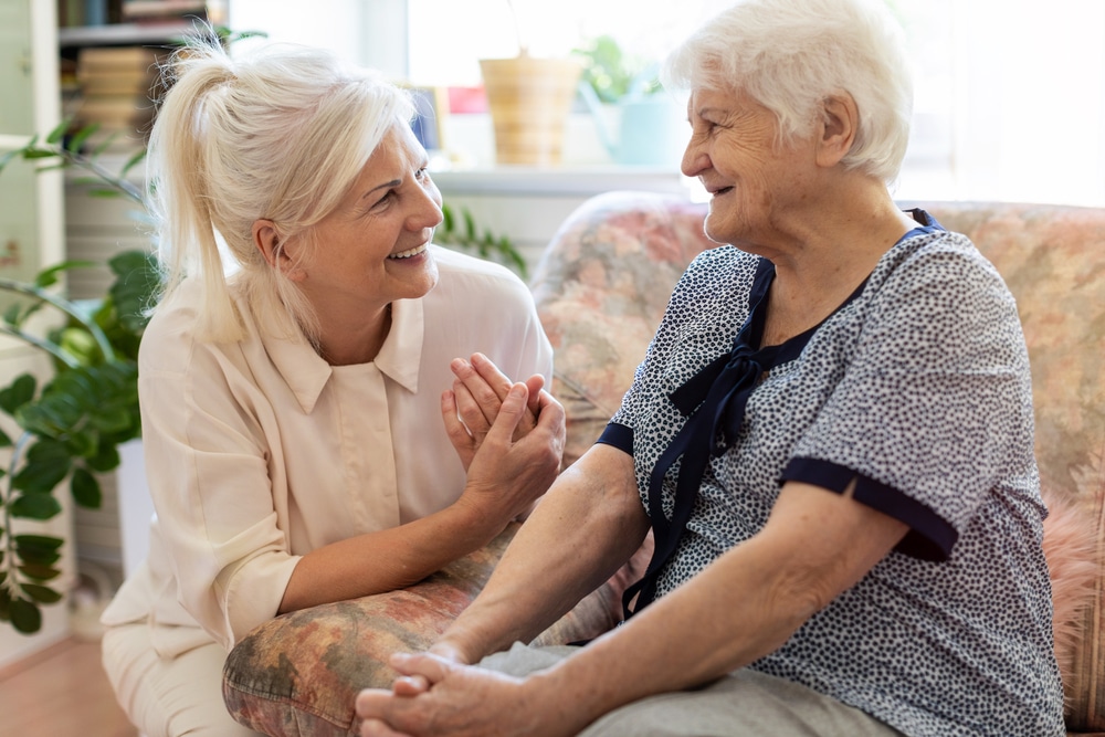 Senior woman talking with smiling middle-aged woman indoors