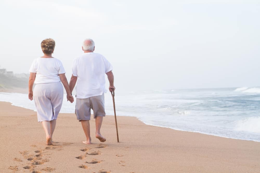 Senior couple walking on the beach together